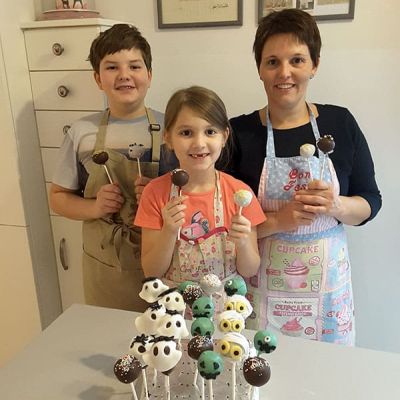 Mutter gestaltet mit Kindern Cake Pops mit gruseligen Geistern und Monstern