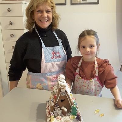 Oma gestaltet mit Enkelin ein Lebkuchenhaus 