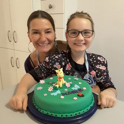 Mutter und Tochter gestalten grüne Torte mit Giraffe 