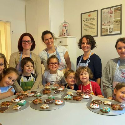 Eltern und Kinder verzieren Lebkuchen bei Con Festi Nahe Innsbruck