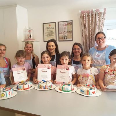 Kinder gestalten gemeinsam mit ihren Müttern eine Schulstart-Torte