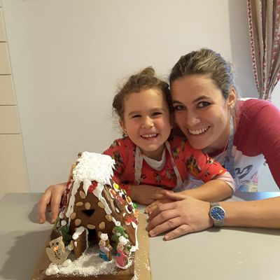 Mutter und Tochter machen ein Lebkuchenhaus