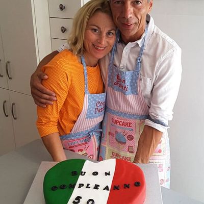 Pärchen backt und gestaltet Geburtstagstorte in Herzform in Italiendesign